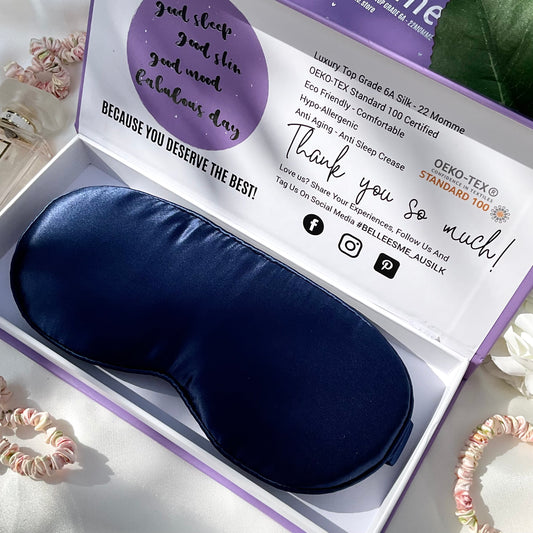 A navy blue 3D contour sleep mask made of mulberry silk, presented in an open gift box 